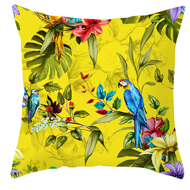 Decorative pillow with tropical birds and flowers on a yellow background