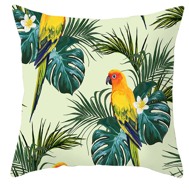 Decorative pillow with tropical leaf and parrot design on a light green background
