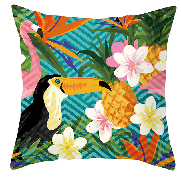 Decorative pillow with tropical design featuring a toucan, pineapple, and flowers on a colorful background.