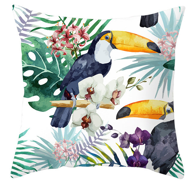 Decorative pillow with toucan and floral design on a white background