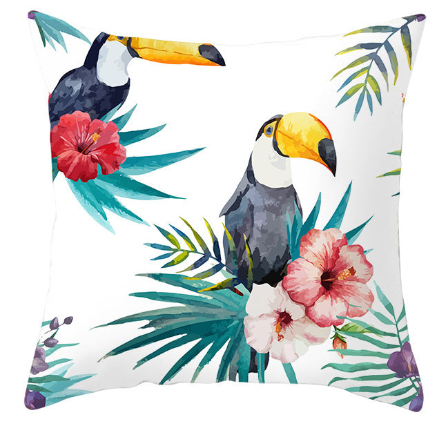 Decorative pillow with toucan and floral design on a white background