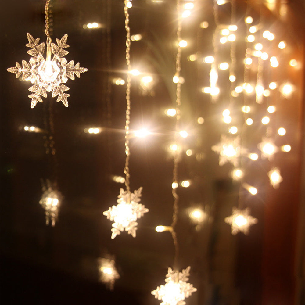 Decorative string lights shaped like snowflakes on a dark background