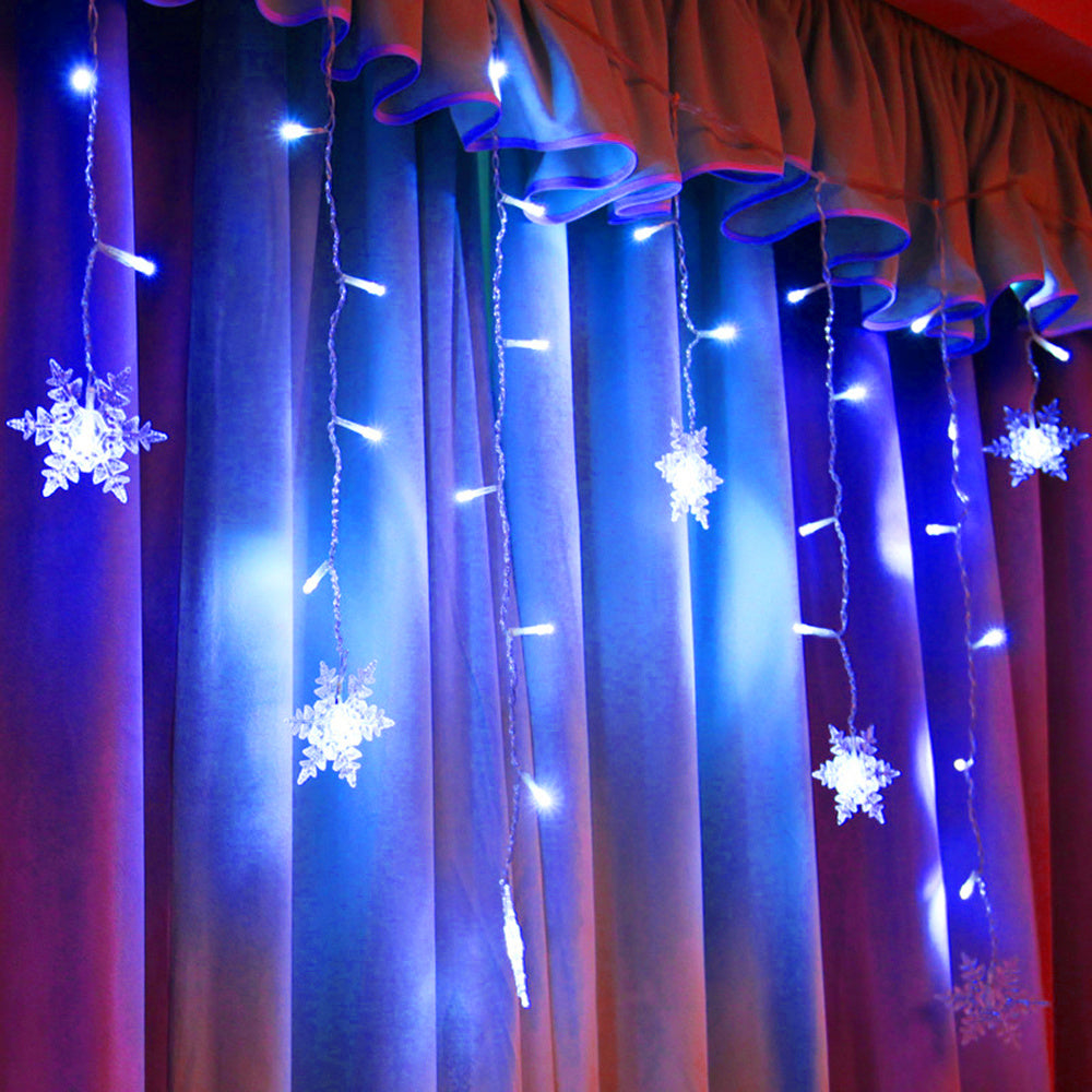 Snowflake string lights hanging on a curtain with a red background