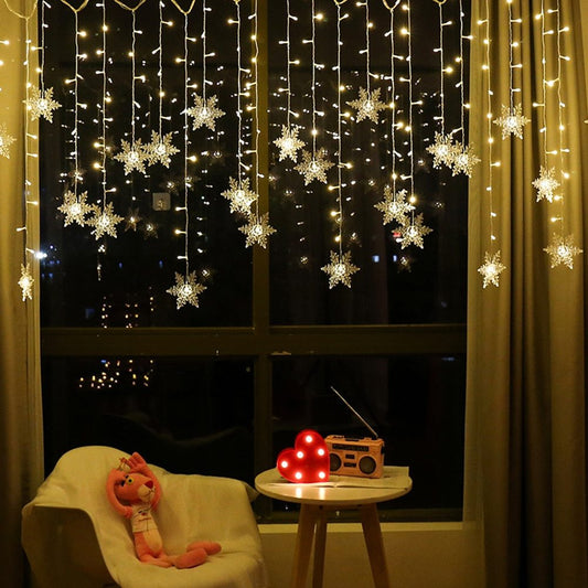 Decorative string lights with snowflake ornaments on a window, creating a cozy indoor setting.