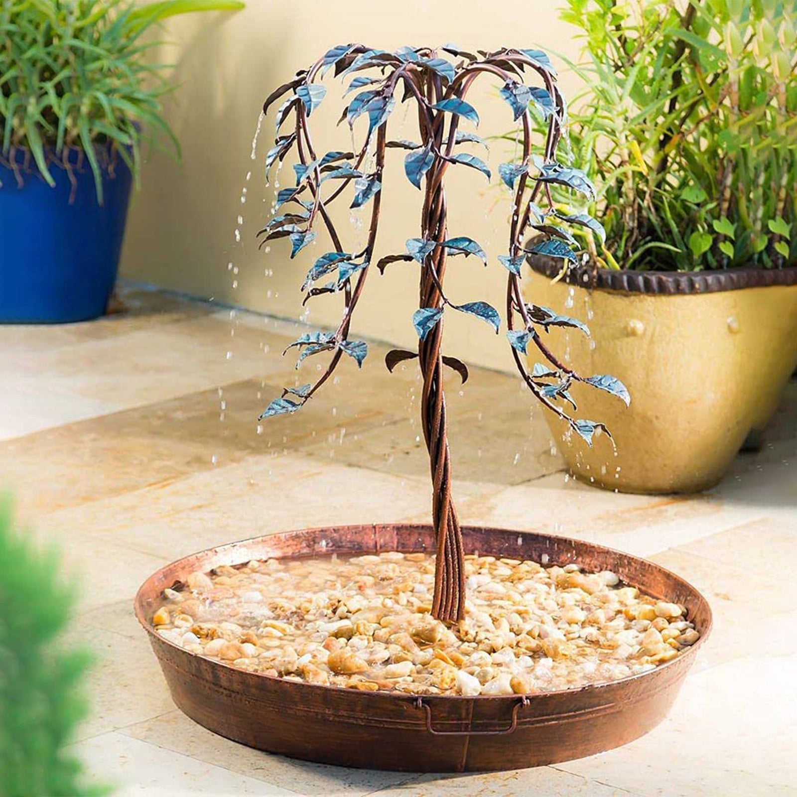Decorative metal tree with water feature in a bowl on a patio