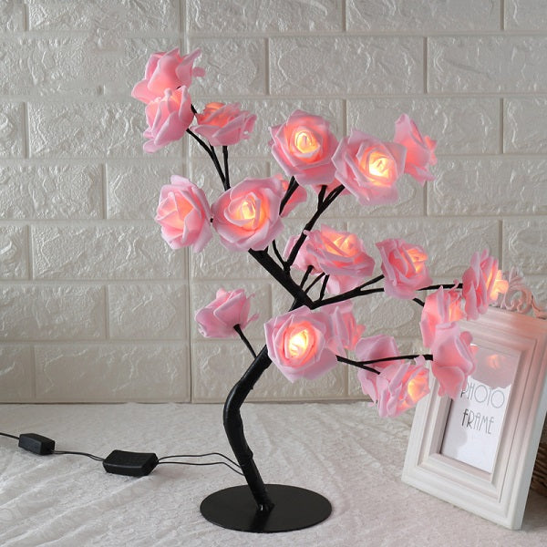 Decorative LED lamp with pink flowers on a white brick wall background