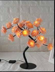 Decorative lamp with orange flower-shaped lights on a white surface.