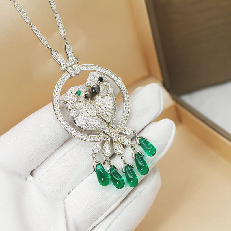 Luxury diamond and emerald pendant on a white glove with a beige background
