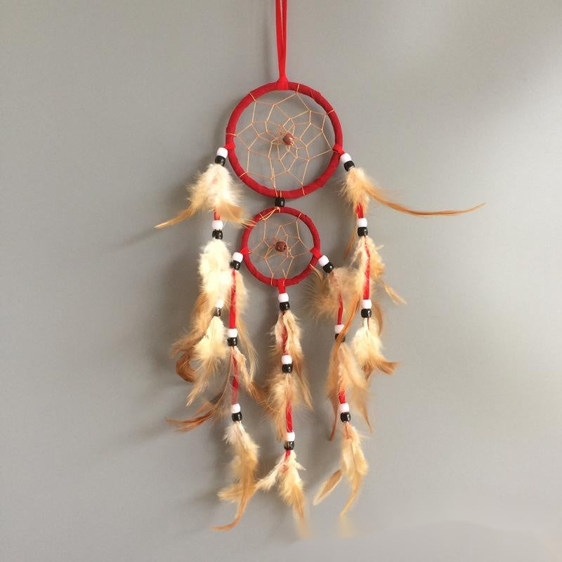 Red dreamcatcher with feathers on a gray background