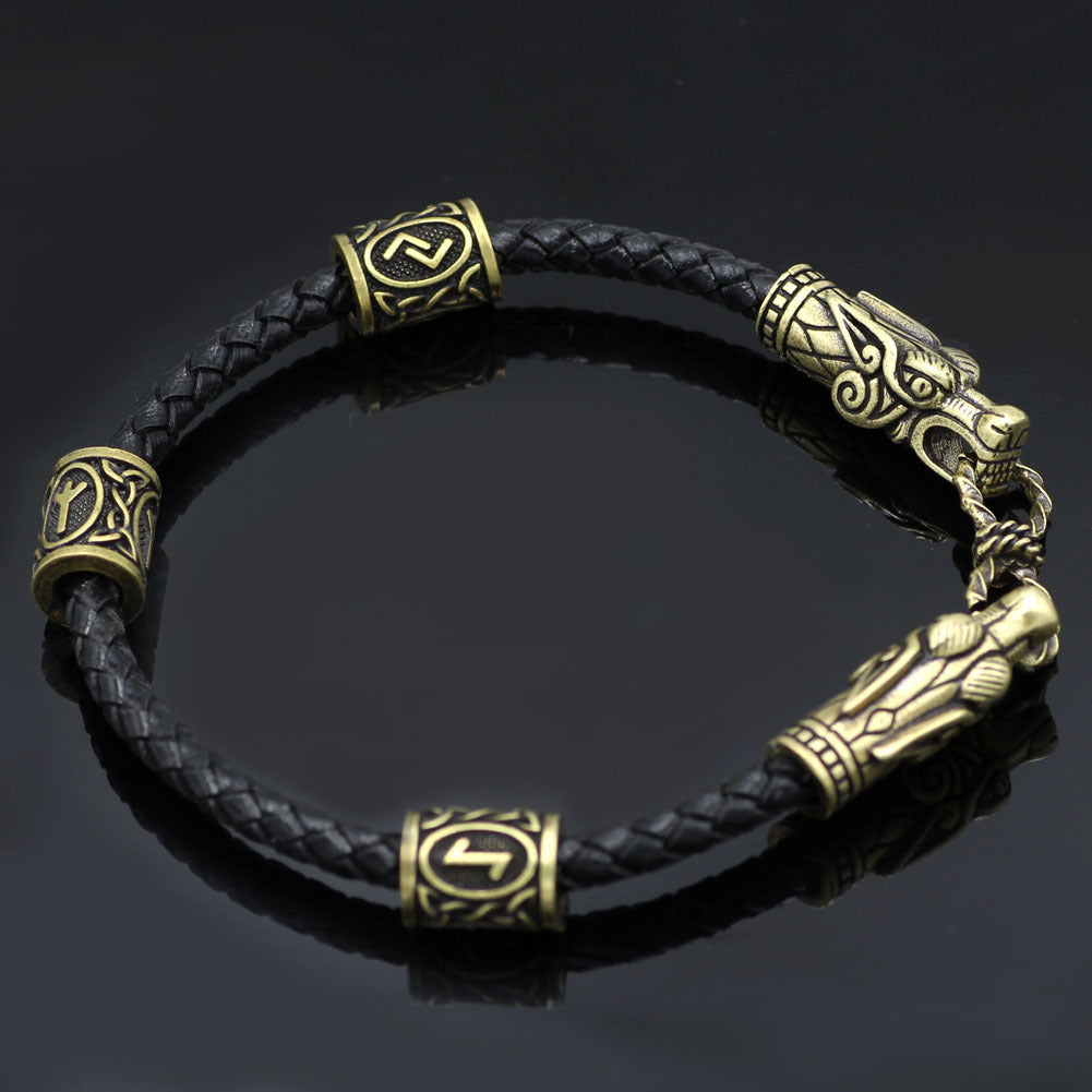 Black braided leather bracelet with gold dragon head clasp on a dark background
