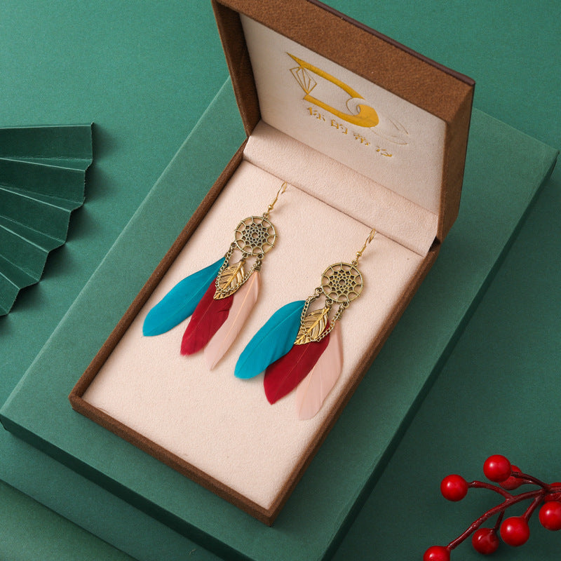 Colorful earrings in a jewelry box on a green background