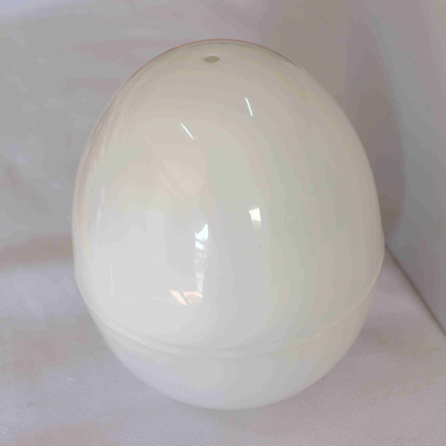 White ceramic egg-shaped object on a white background