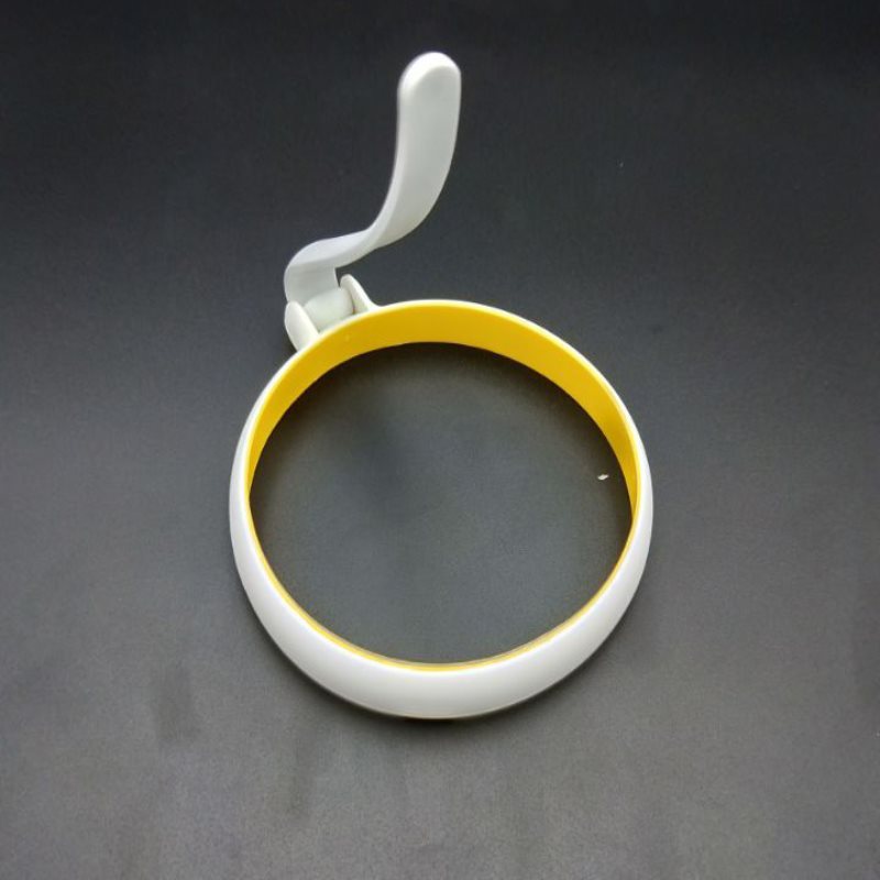 White and yellow ring holder on a dark gray background
