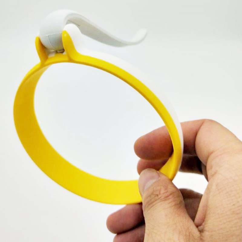 Yellow and white kitchen tool held by a hand against a white background