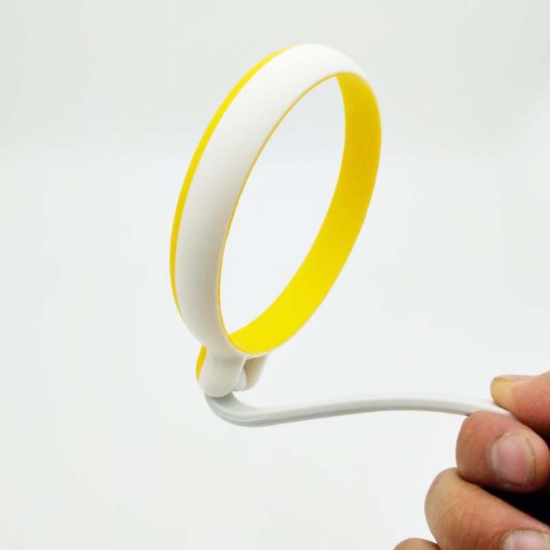 White and yellow hair tie held by a hand on a white background