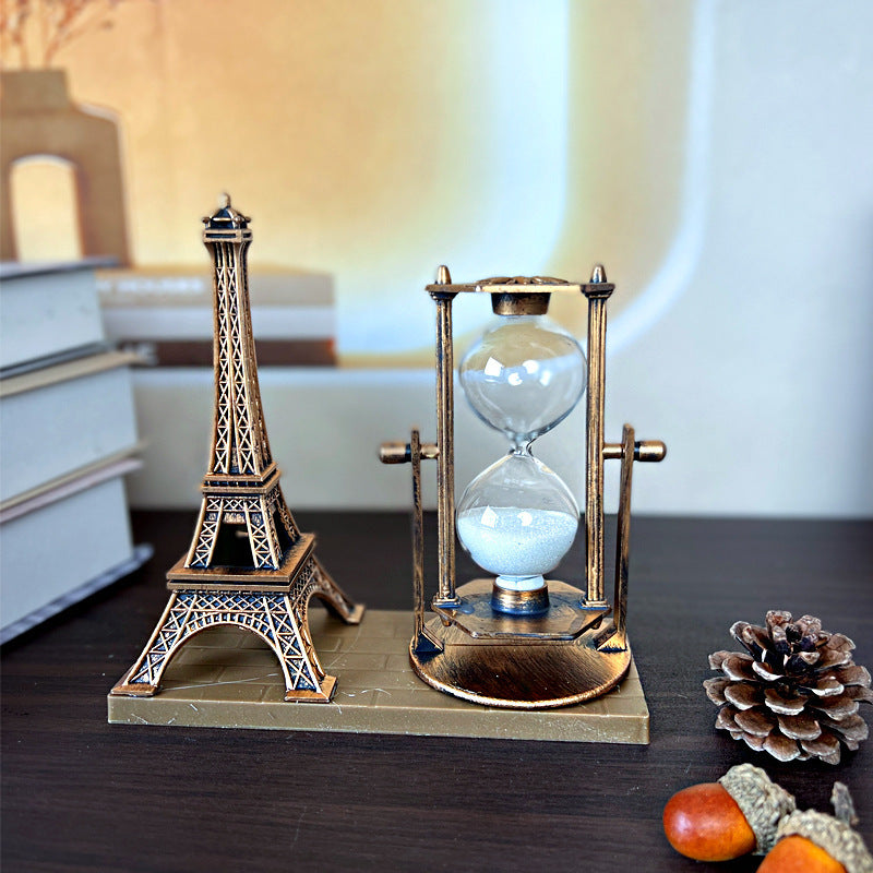 Decorative hourglass with Eiffel Tower design on a wooden surface