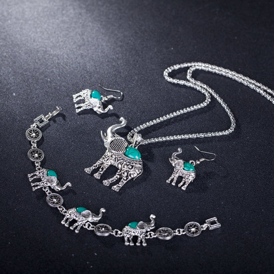 Silver elephant jewelry set with turquoise stones on a black background