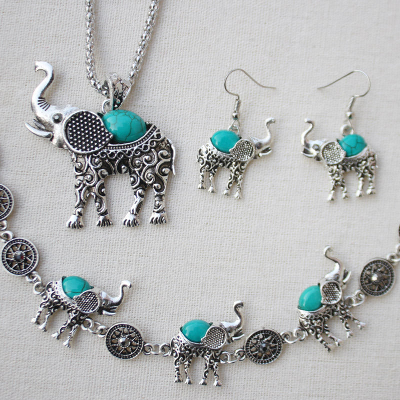 Jewelry set with elephant designs featuring turquoise stones on a light background