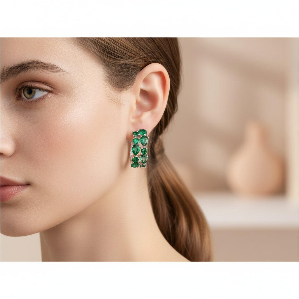 Pair of green gemstone earrings with silver accents on a woman