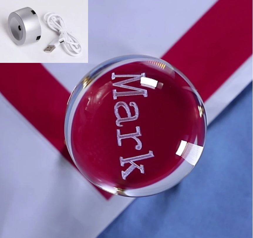 Red crystal ball with 'Mark' engraved, USB cable inset, on a striped background
