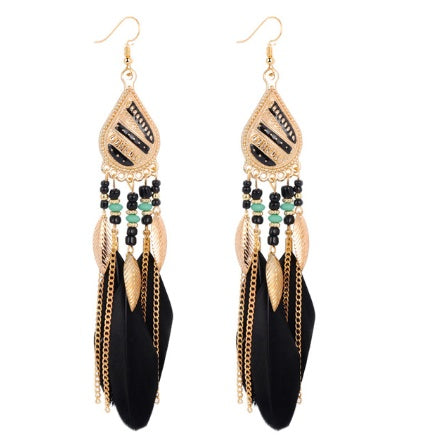 Pair of gold and black feather earrings with beads on a white background
