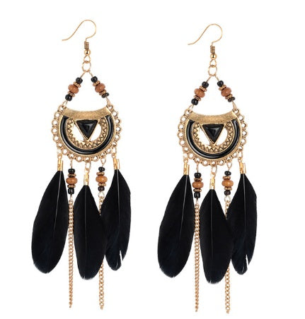 Pair of black feather earrings with gold accents and beads on a white background