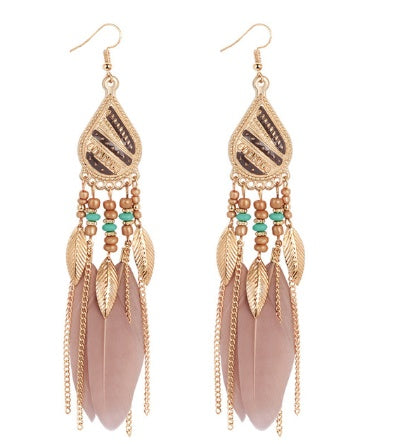 Gold feather earrings with pink feathers and green beads on a white background