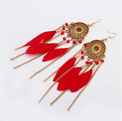 Red feather earrings with gold accents on a white background