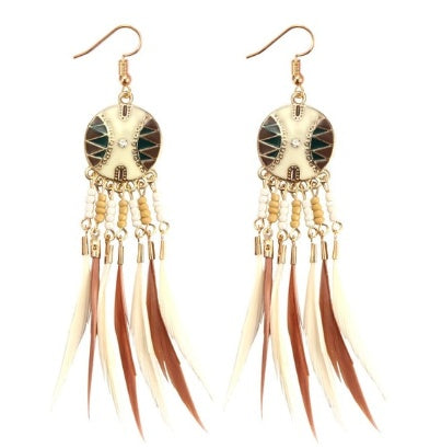 Gold-framed earrings with feather tassels on a white background