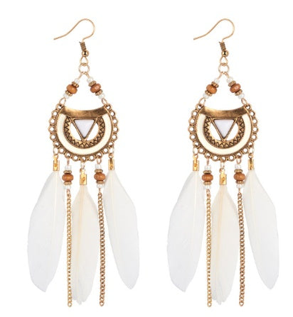Gold and white feather earrings on a white background