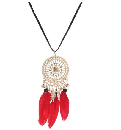 Necklace with a gold-colored dreamcatcher pendant and red feathers on a white background