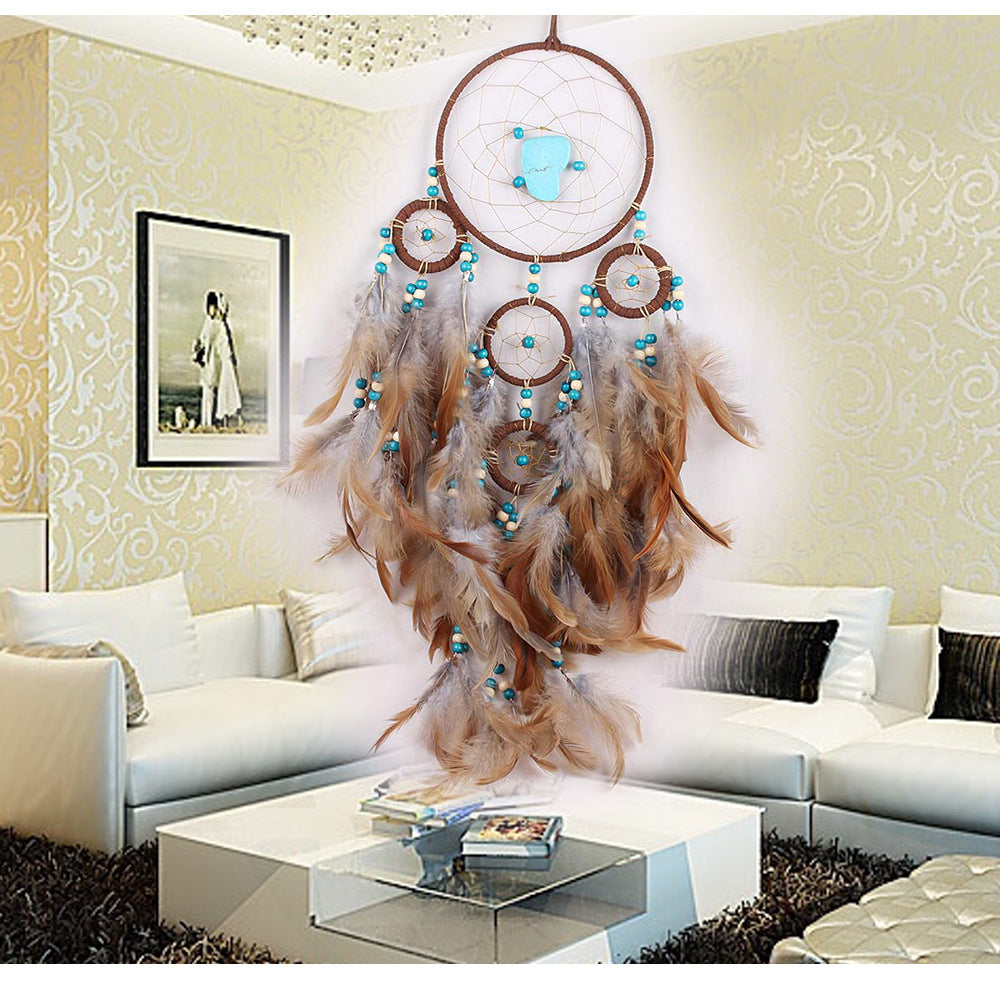 Decorative dreamcatcher with feathers and beads in a living room setting.