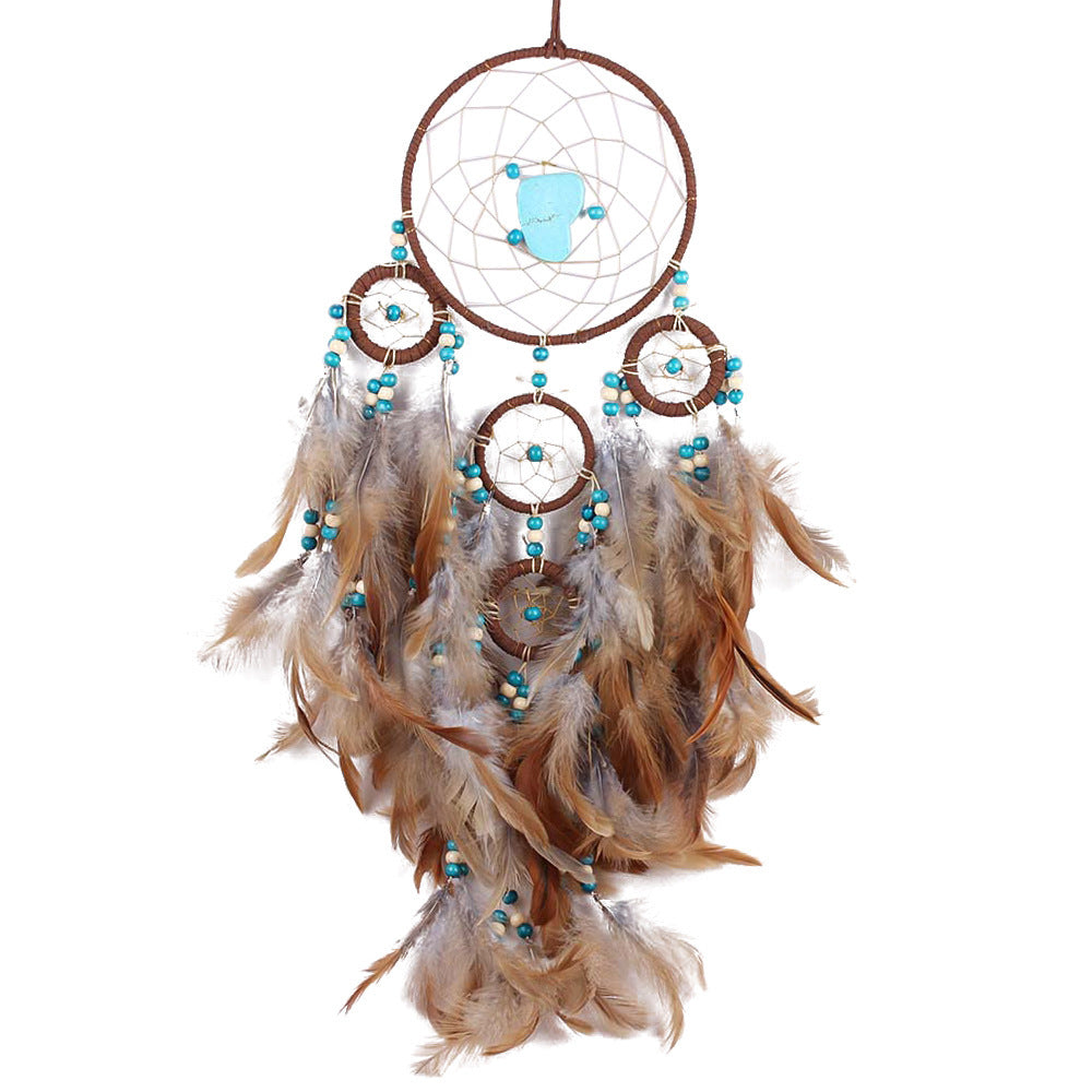 Dreamcatcher with feathers and turquoise beads on a white background