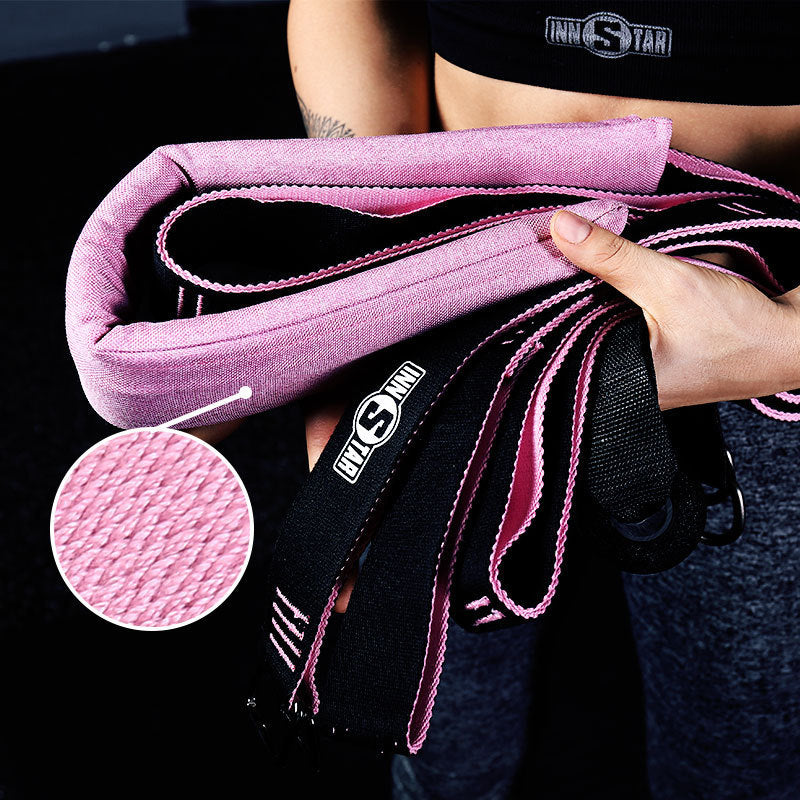 Person holding a pink and black resistance band with close-up of texture and brand logo.