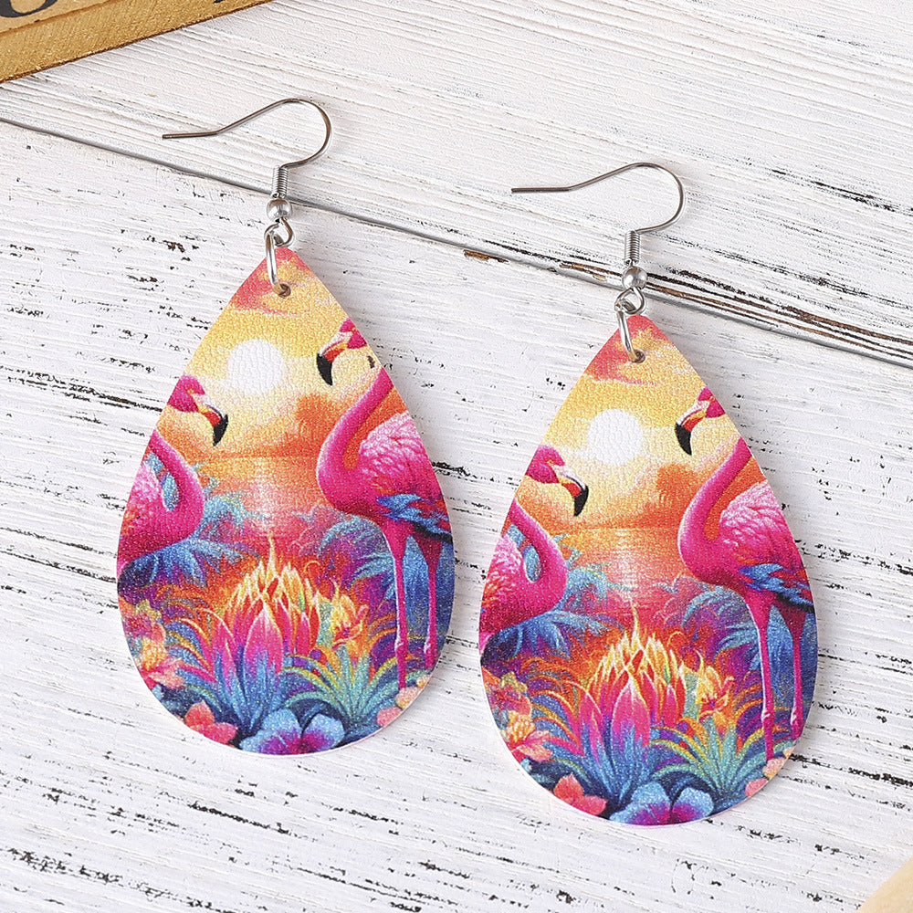 Colorful flamingo earrings on a wooden surface