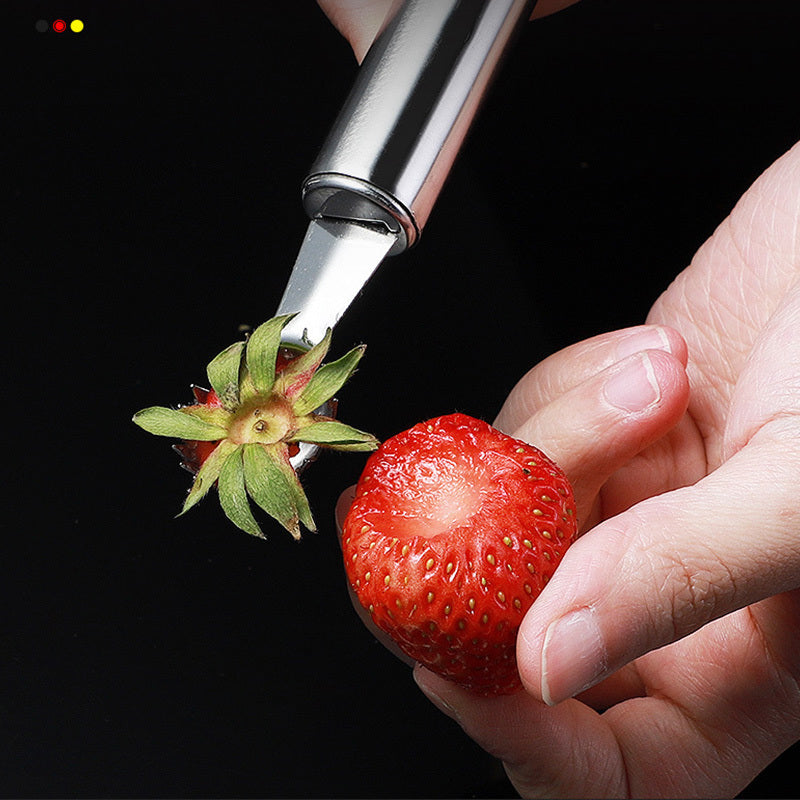 Strawberry being pierced with a metal tool against a black background