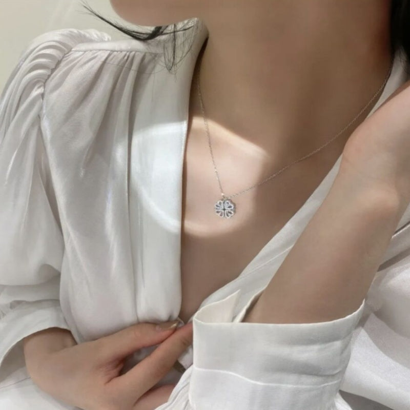 Person wearing a delicate necklace with a small pendant against a neutral background
