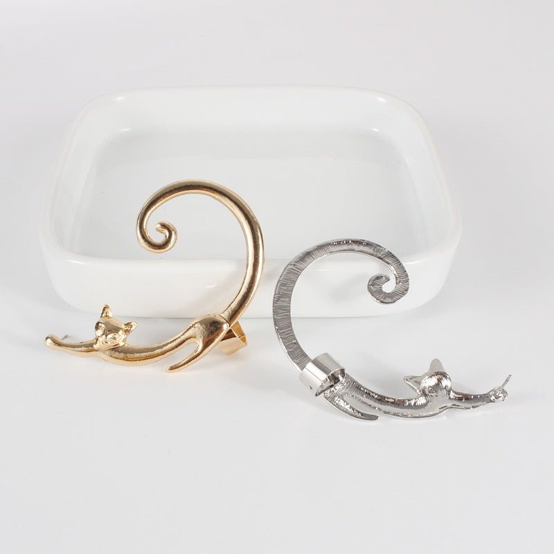 Gold and silver cat-shaped earrings on a white background