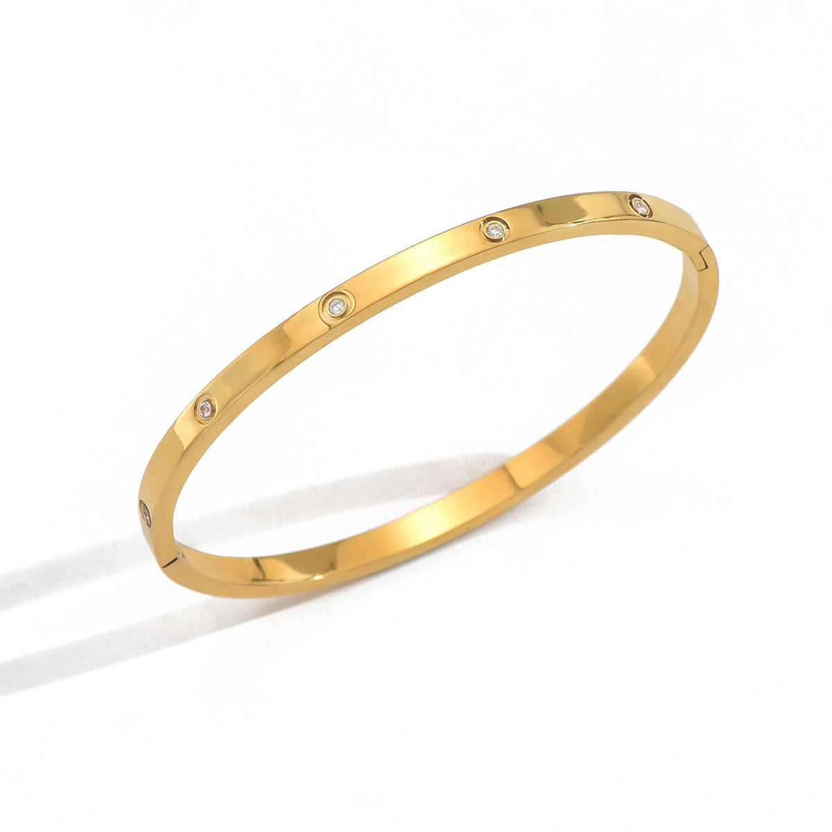 Gold bracelet with small diamonds on a white background