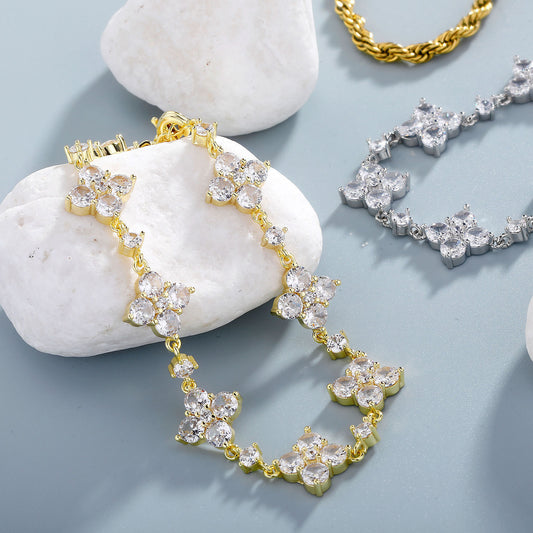 Gold and silver bracelet on white stones with a light blue background