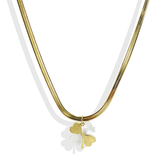 Gold necklace with a white flower pendant on a white background