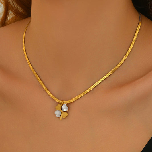 Gold necklace with a clover-shaped pendant on a model
