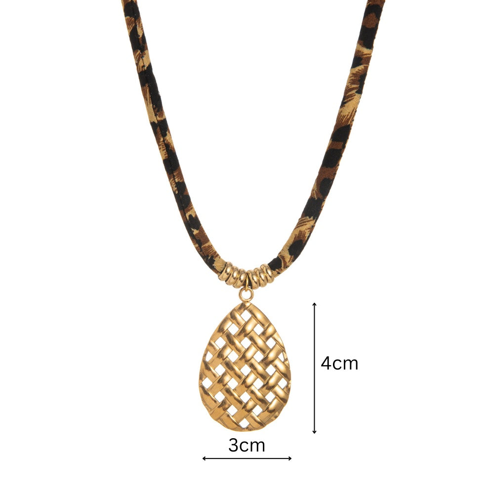 Gold necklace with a patterned cord and gold pendant on a white background