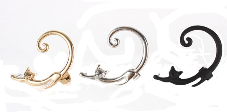 Three cat-shaped earrings in gold, silver, and black on a white background