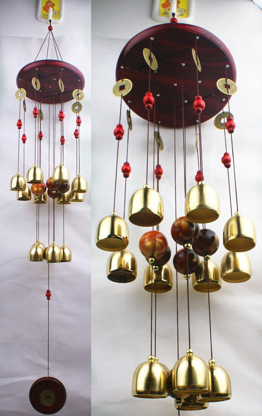 Decorative hanging bell chime with gold and red elements on a white background