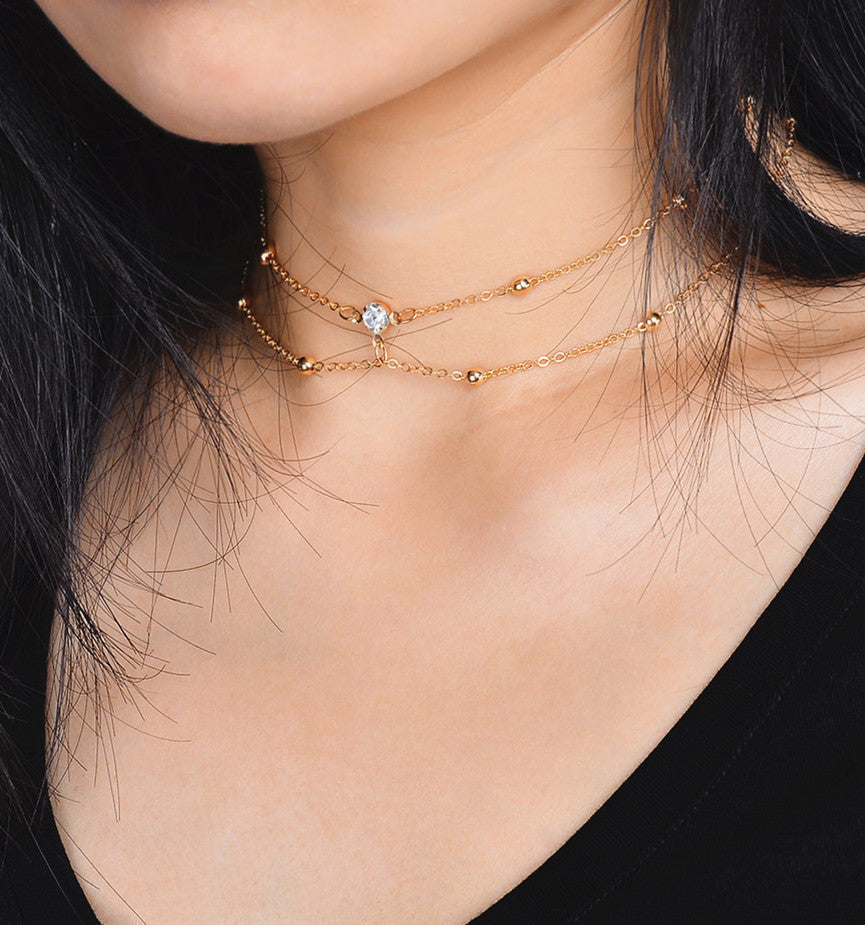 Double gold necklace with zirconia stone and gold balls
