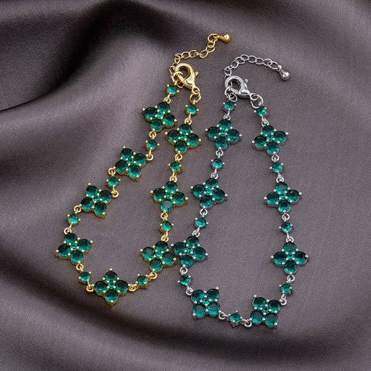 Two green gemstone bracelets on a gray fabric background