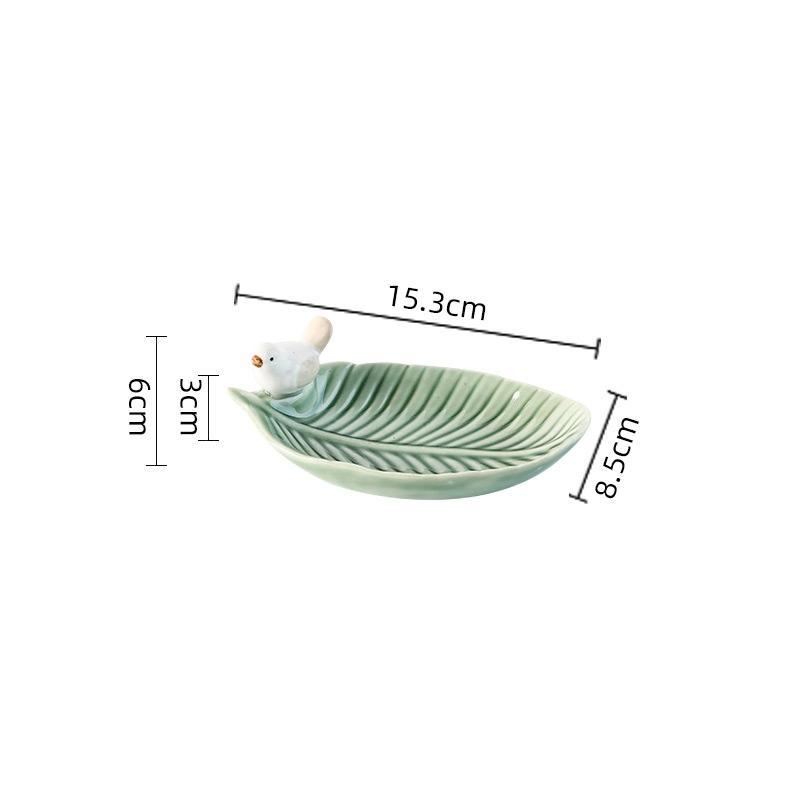 Green ceramic leaf-shaped dish with measurements on a white background