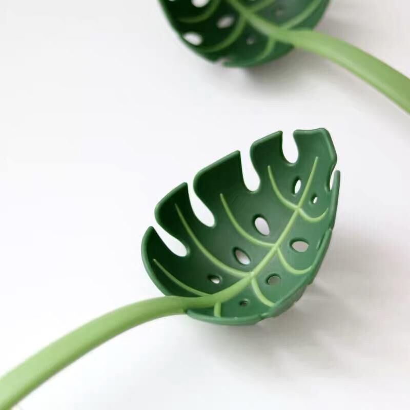 Green leaf-shaped pot holder on a white background