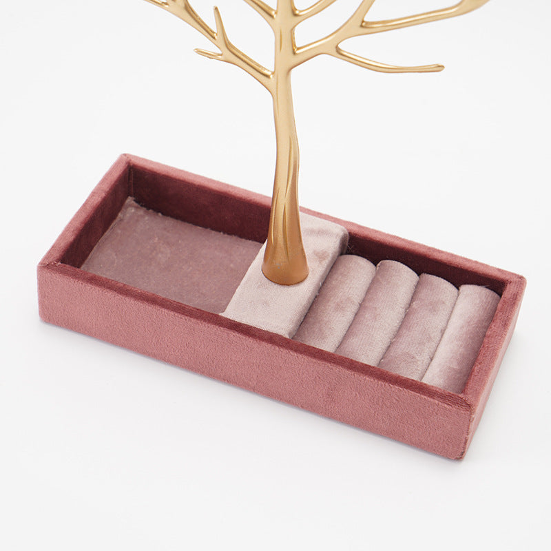Pink jewelry tray with gold tree stand on a white background